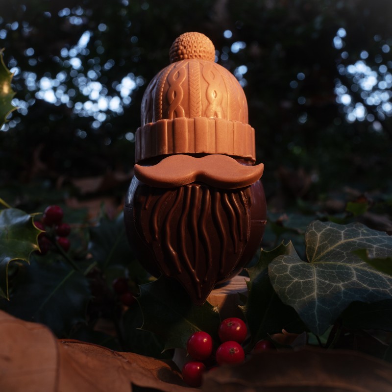 personnage en chocolat lait et noir ressemblant à un père Noel avec un bonnet enfoncé jusqu'au yeux