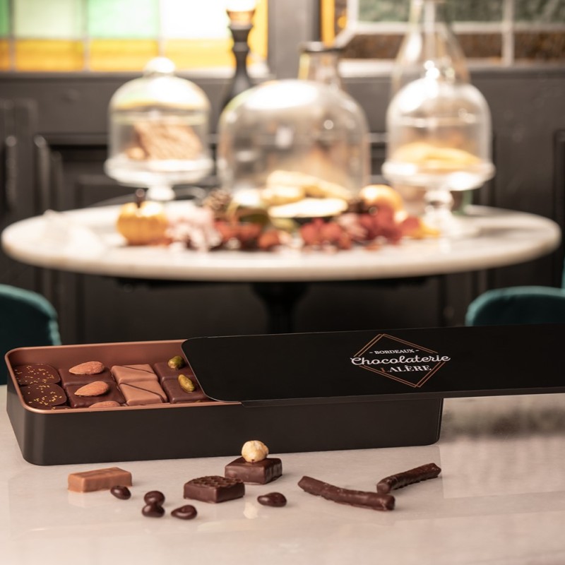 Ecrin en boite métal regroupant un assortiment de divers chocolats, ganaches et pralinés.