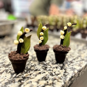 trois brins de muguet en chocolat dans un pot en chocolat lait ou noir