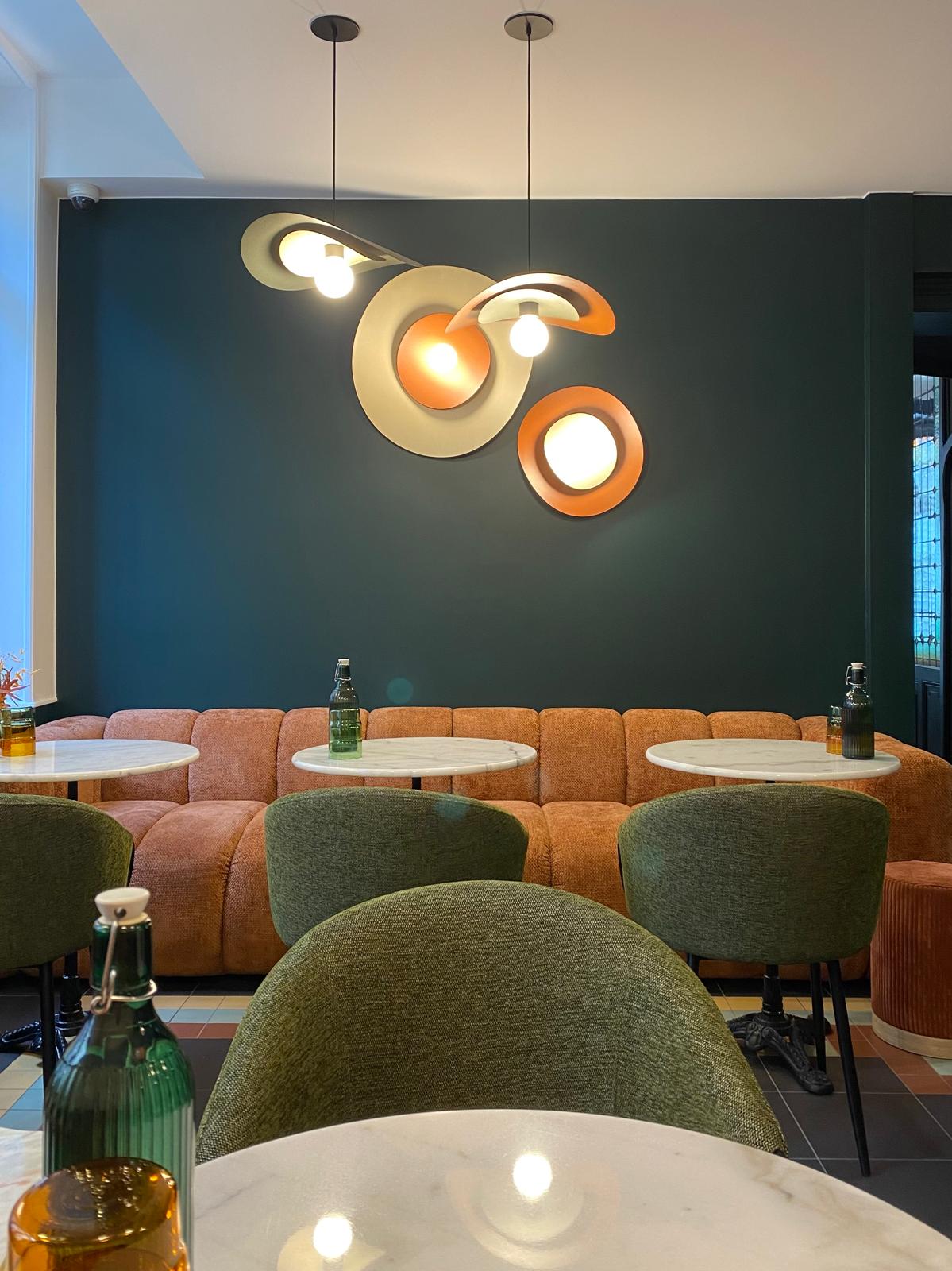 tables ronde en marbre blanc, chaise en tissus vert, canapé en tissus rouille